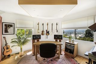 A music room with speakers and guitars hung on the wall