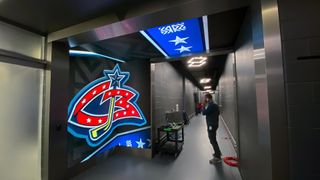 Digital displays from SNA Displays show the Columbus Blue Jackets logo as a player walks down a hallway.