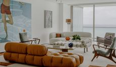 A living room with a white sofa, and a leather sofa in tan color