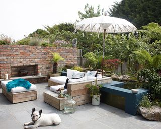 garden with brick wall wooden sofa and cushions
