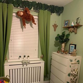 Zoo themed green nursery with white cot