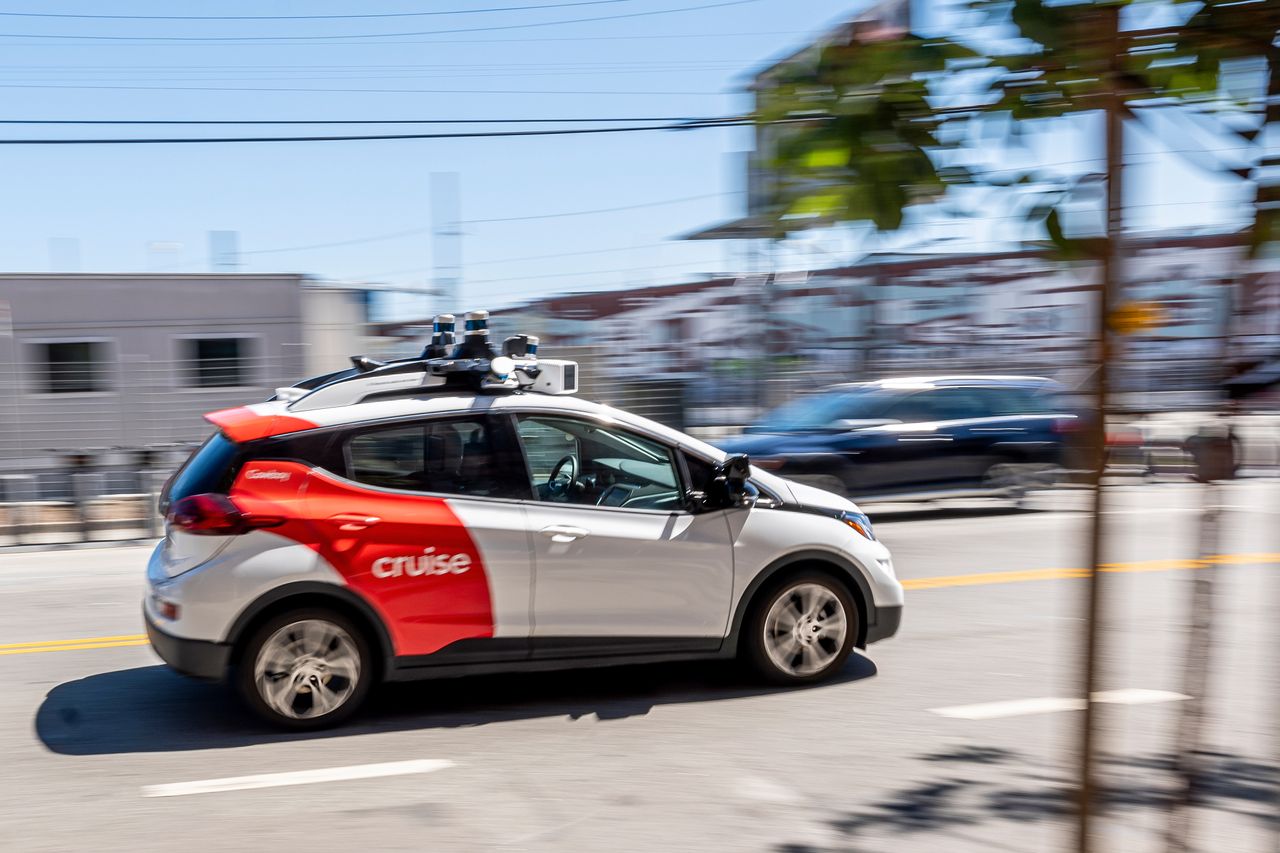 A Cruise driverless taxi moves through a street in California