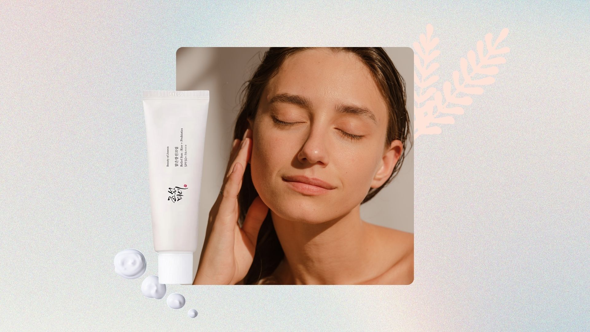 A woman&#039;s face and neck, with brown hair, a clean face and her hand touching her jawline, next to an image of beauty of Joseon SPF50 and some little droplets of cream, plus an illustration of a pink leaf