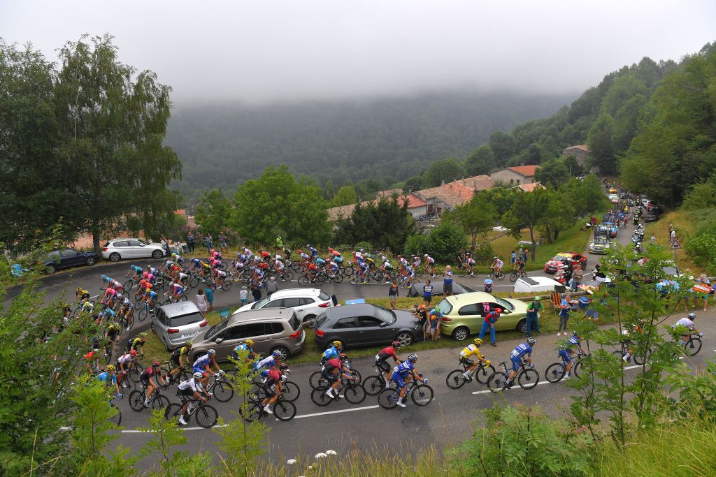 The peloton wind their way up a climb