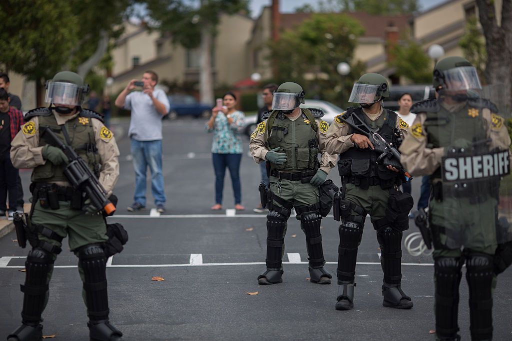 Protesters gather after an off-duty police officer fired a warning shot around kids.