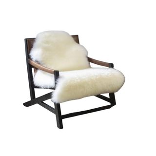 A white genuine sheepskin rug thrown over an accent chair