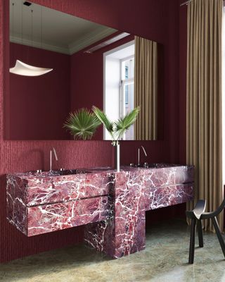 A bathroom with burgundy walls and pink sink
