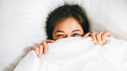 Woman waking up happy in bed