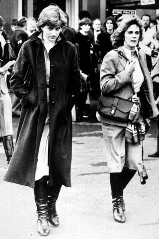 Princess Diana wears a long dark coat and black leather boats as she attends the Ludlow Races to watch King Charles compete in 1980 with Camilla Parker Bowles