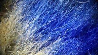 Detailed texture of blue and cream colored furry fabric.