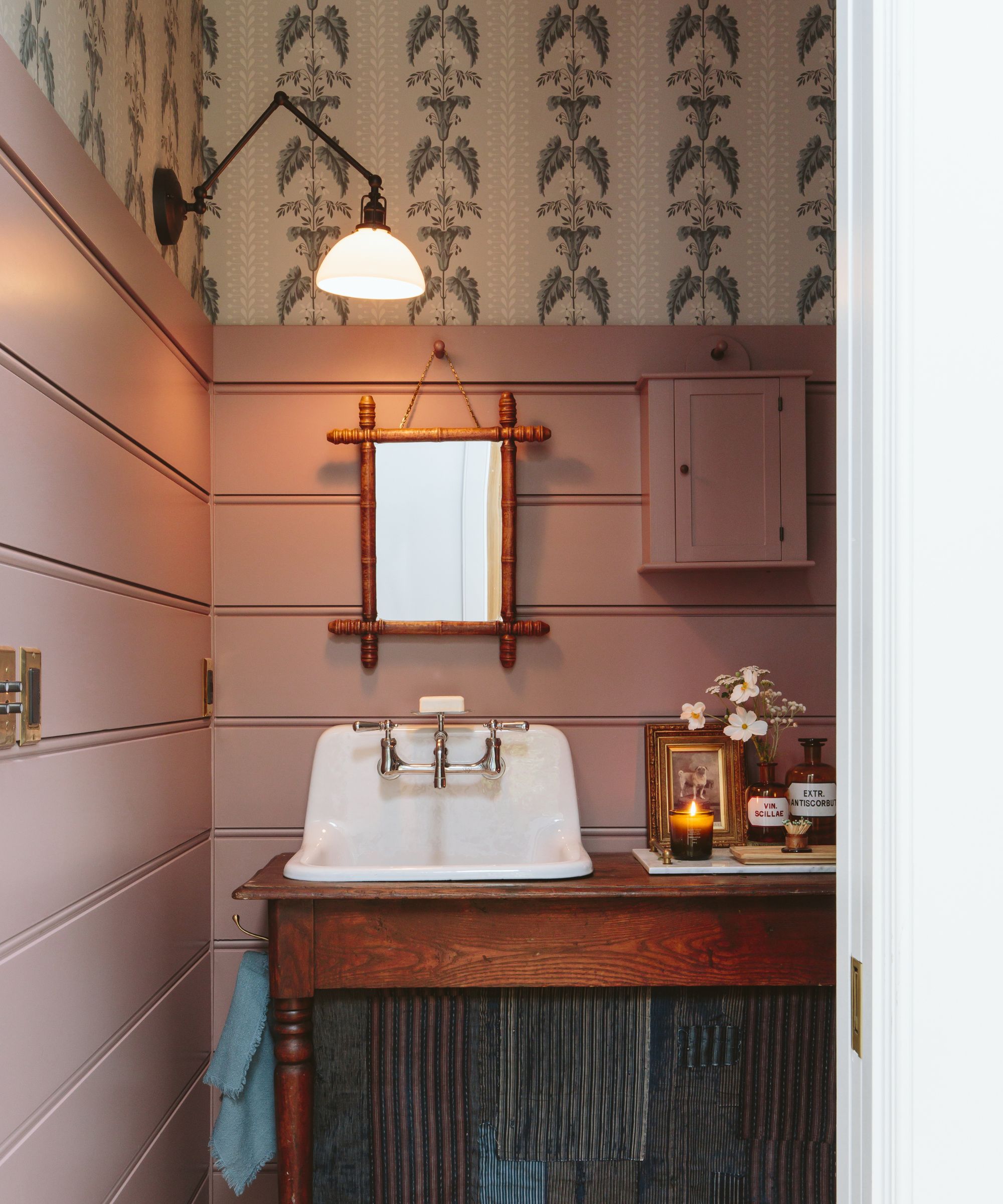 pink and blue bathroom with paneled and wallpaper walls