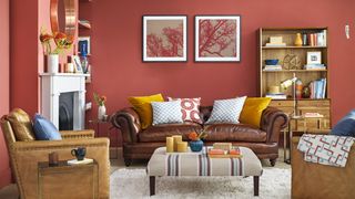 Living room with red walls and leather sofa suggested as paint color that could devalue your home