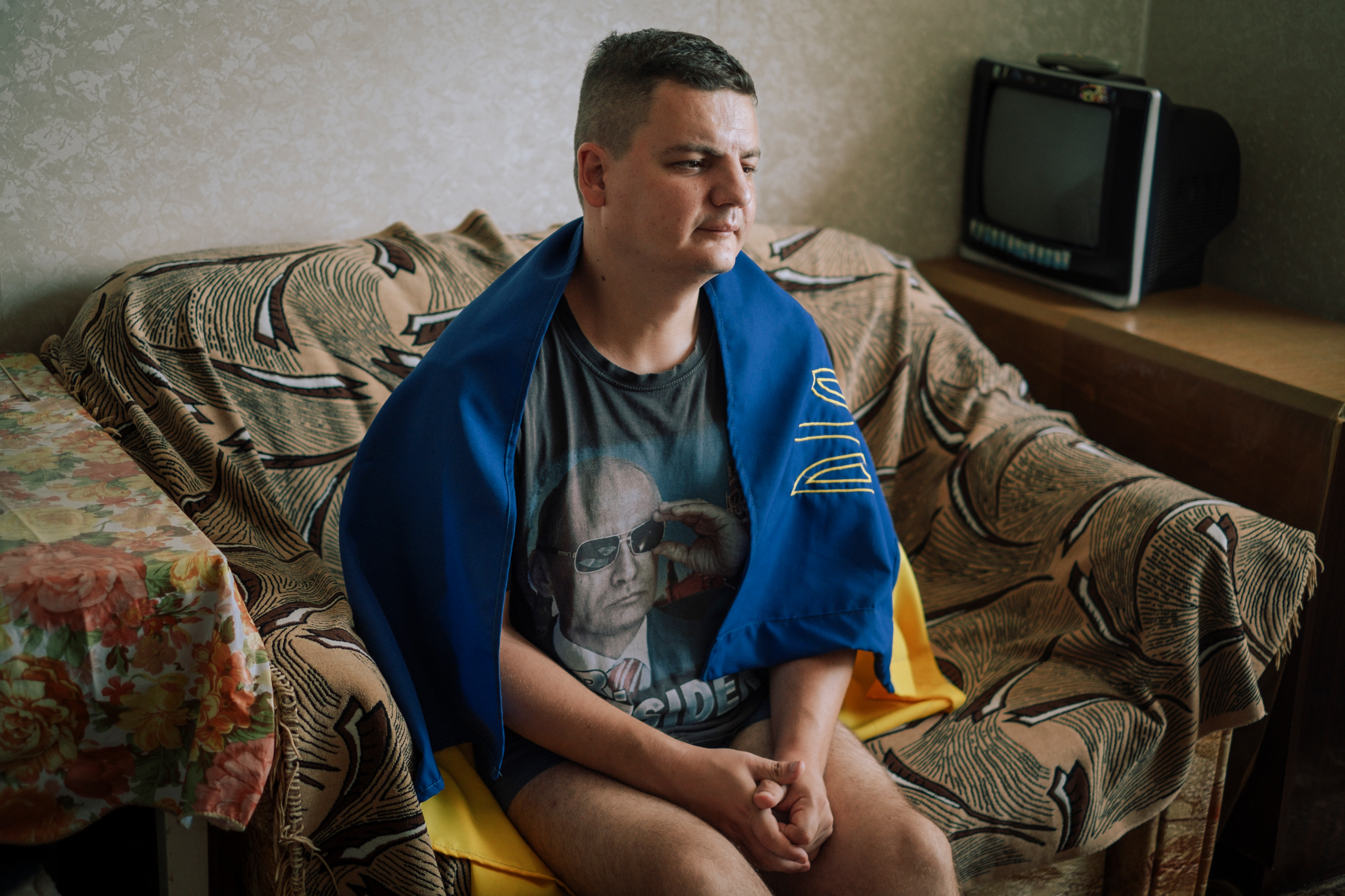 Valera on the sofa in his living room. Tiraspol, Transnistria, Republic of Moldova 2023. From the series “Bright Memory”