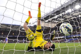 Chelsea's Belgian goalkeeper Thibaut Courtois falls after failing to keep out a long range goal from Stoke City's Scottish midfielder Charlie Adam (unseen) to equalise 1-1 during the English Premier League football match between Chelsea and Stoke City at Stamford Bridge in London on April 4, 2015. AFP PHOTO / GLYN KIRK RESTRICTED TO EDITORIAL USE. No use with unauthorized audio, video, data, fixture lists, club/league logos or live services. Online in-match use limited to 45 images, no video emulation. No use in betting, games or single club/league/player publications. (Photo credit should read GLYN KIRK/AFP via Getty Images)