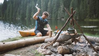 A man chops wood for a campfire