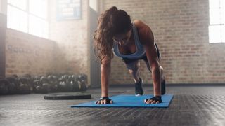 a photo of a woman doing a burpee on an exercise mat