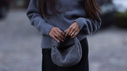 grey jumpers - woman wearing grey wool jumper with feather cuffs and red accessories 1817248191