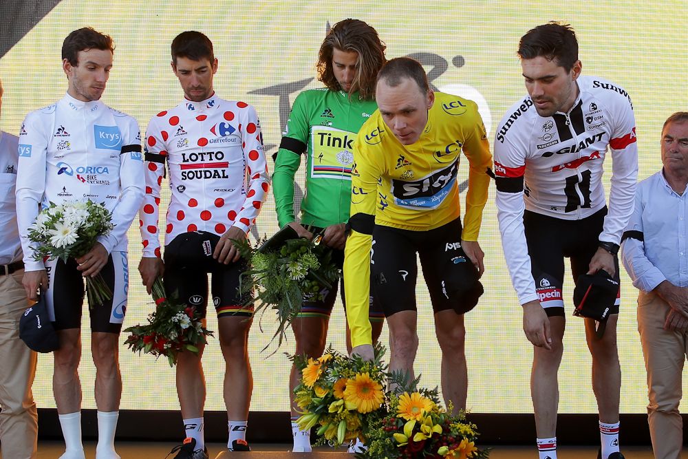 Chris Froome offers flowers to honour the victims of the Nice attack during the stage 13 podium ceremony.