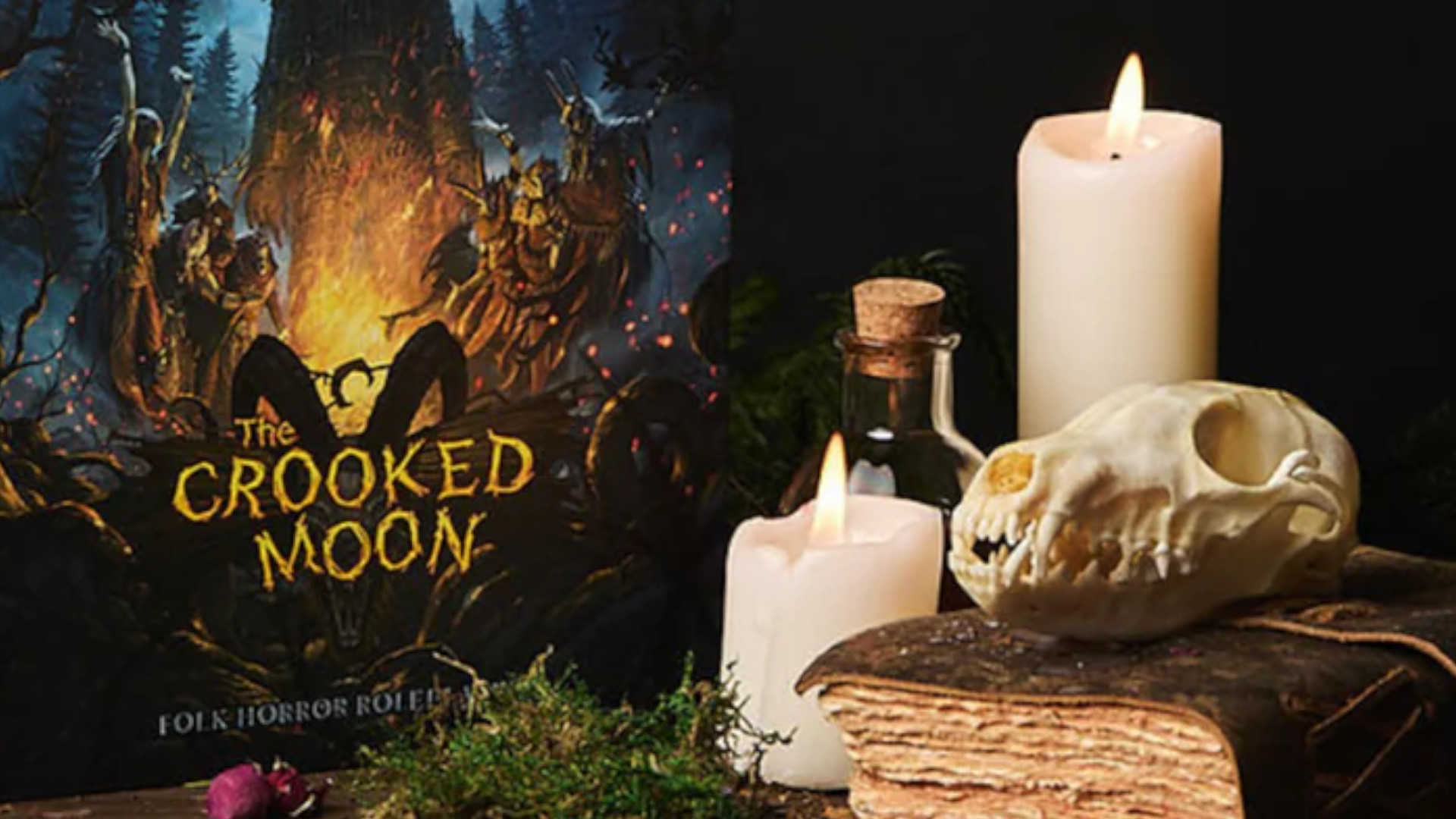 The Crooked Moon book beside a candle and skull on a leather-bound notebook, with a potion bottle visible