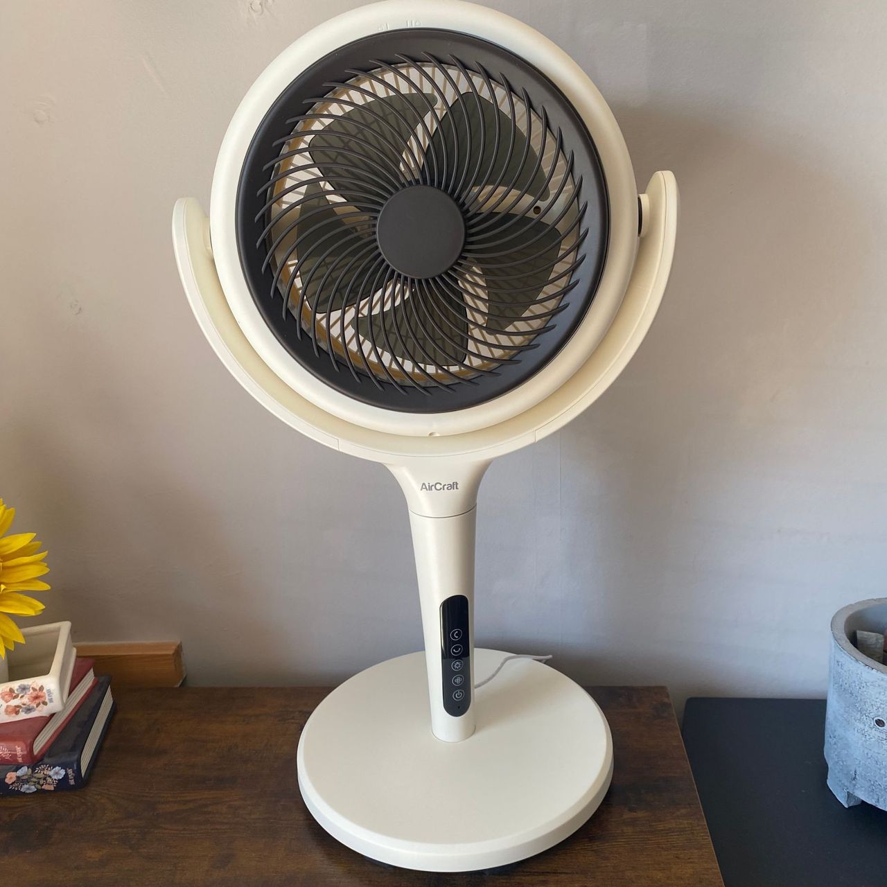 AirCraft LUME Quiet Air Circulator Fan in desktop mode on a side table in front of a taupe wall