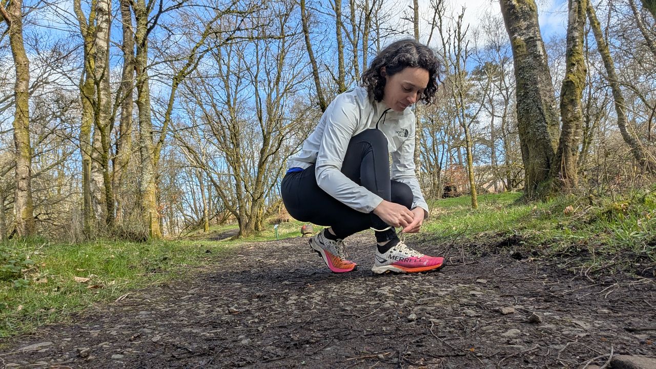A woman tying the laces on her Merrell MTL Long Sky 2 trail running shoes