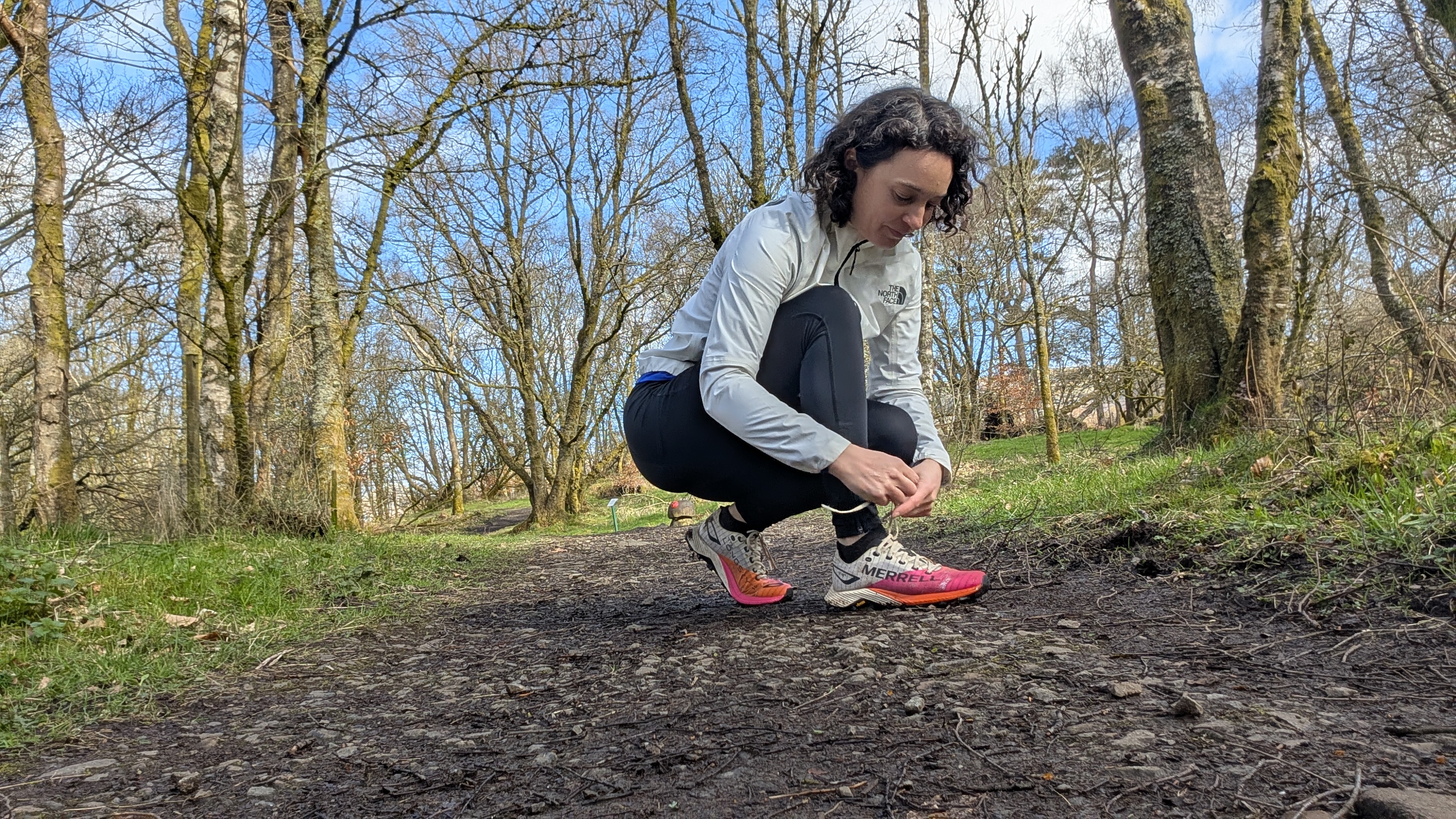 A woman tying the laces on her Merrell MTL Long Sky 2 Matryx trail running shoes