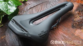 Selle San Marco Ground saddle on a tree stump showing the gloss black on matt black logos and details