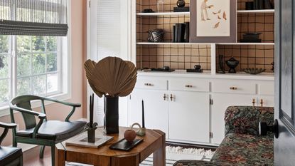 a small office with a shelving unit that has a checkered wallpaper inset into it