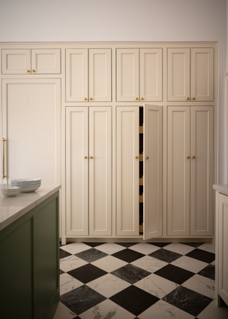 White kitchen cabinetry and black and white tiled flooring