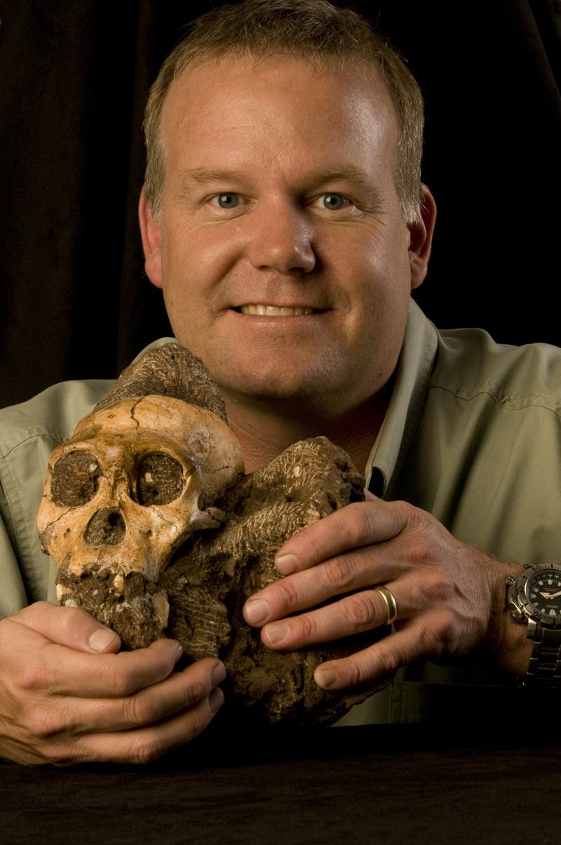 professor holding skull of human ancestor