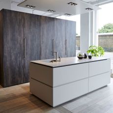 kitchen with brown wooden cupboard white counter and wash basin