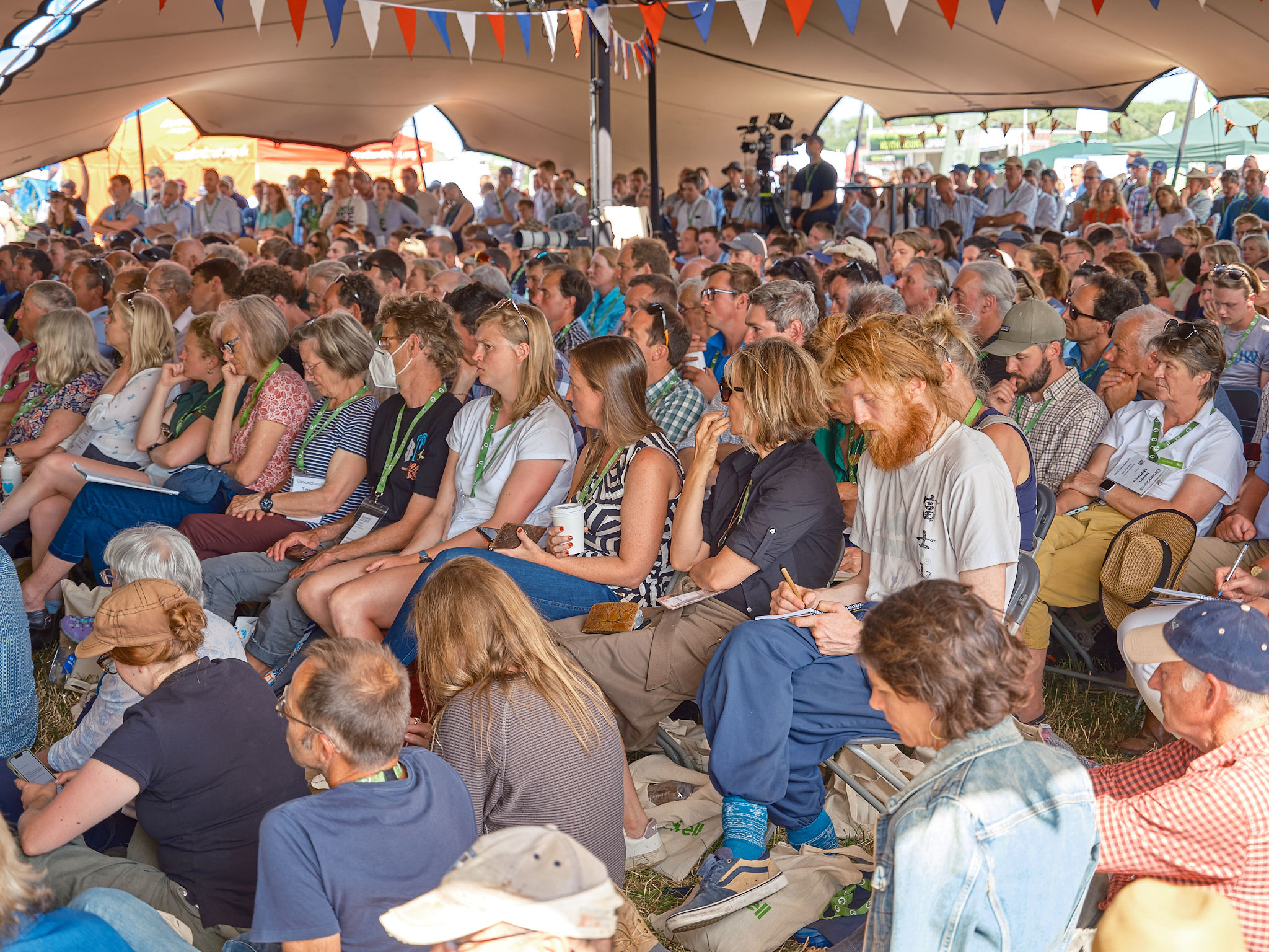 A packed tent listens to a talk at Groundswell