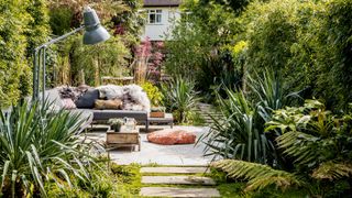 outdoor living space with living room style sofa lamp and coffee table arrangement