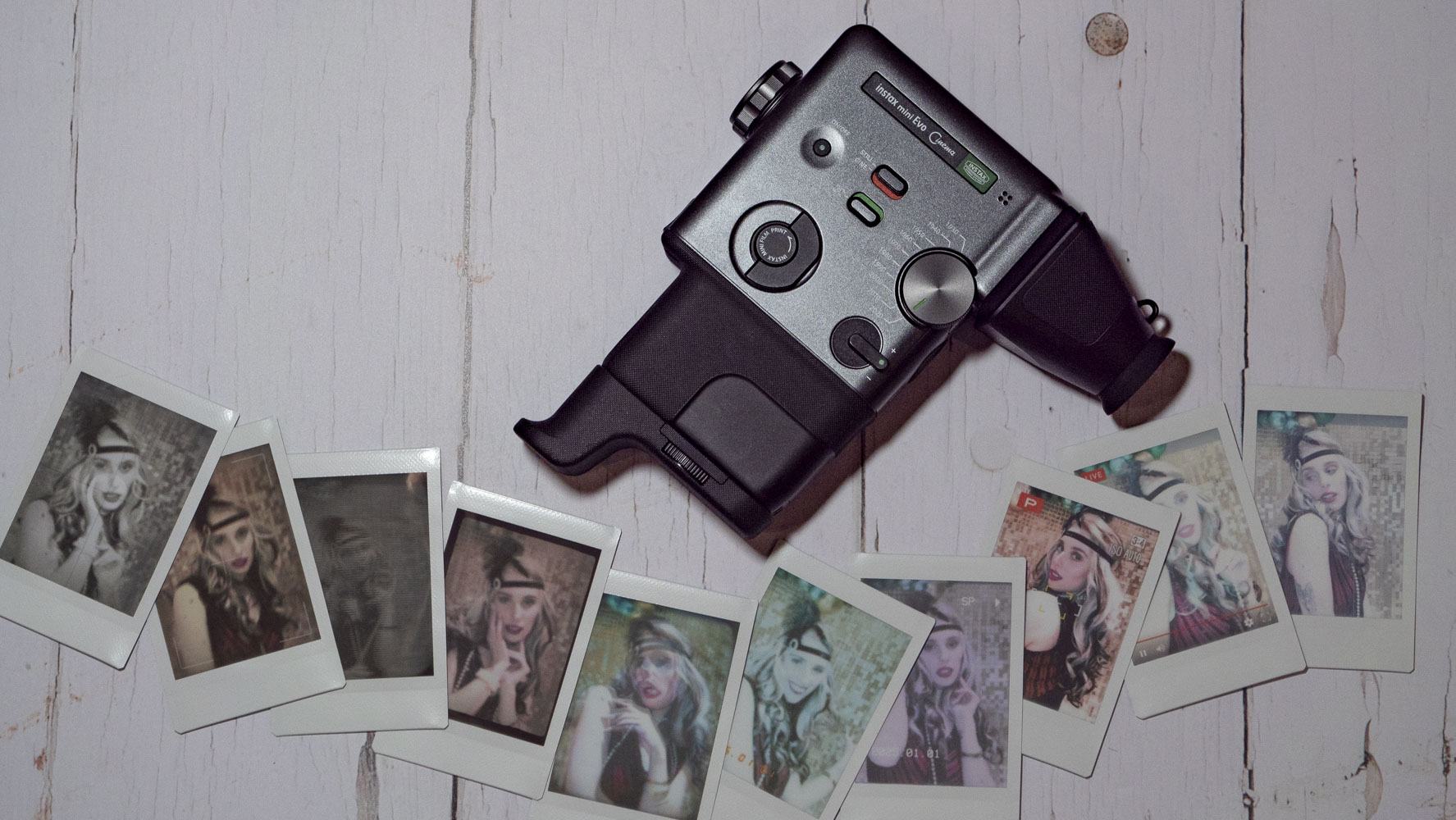 Fujifilm Instax Mini Evo Cinema on a white wooden surface with instant prints around it