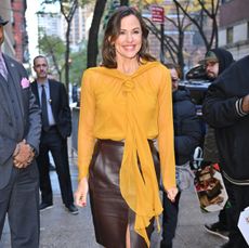 Jennifer Garner in a yellow blouse and brown skirt