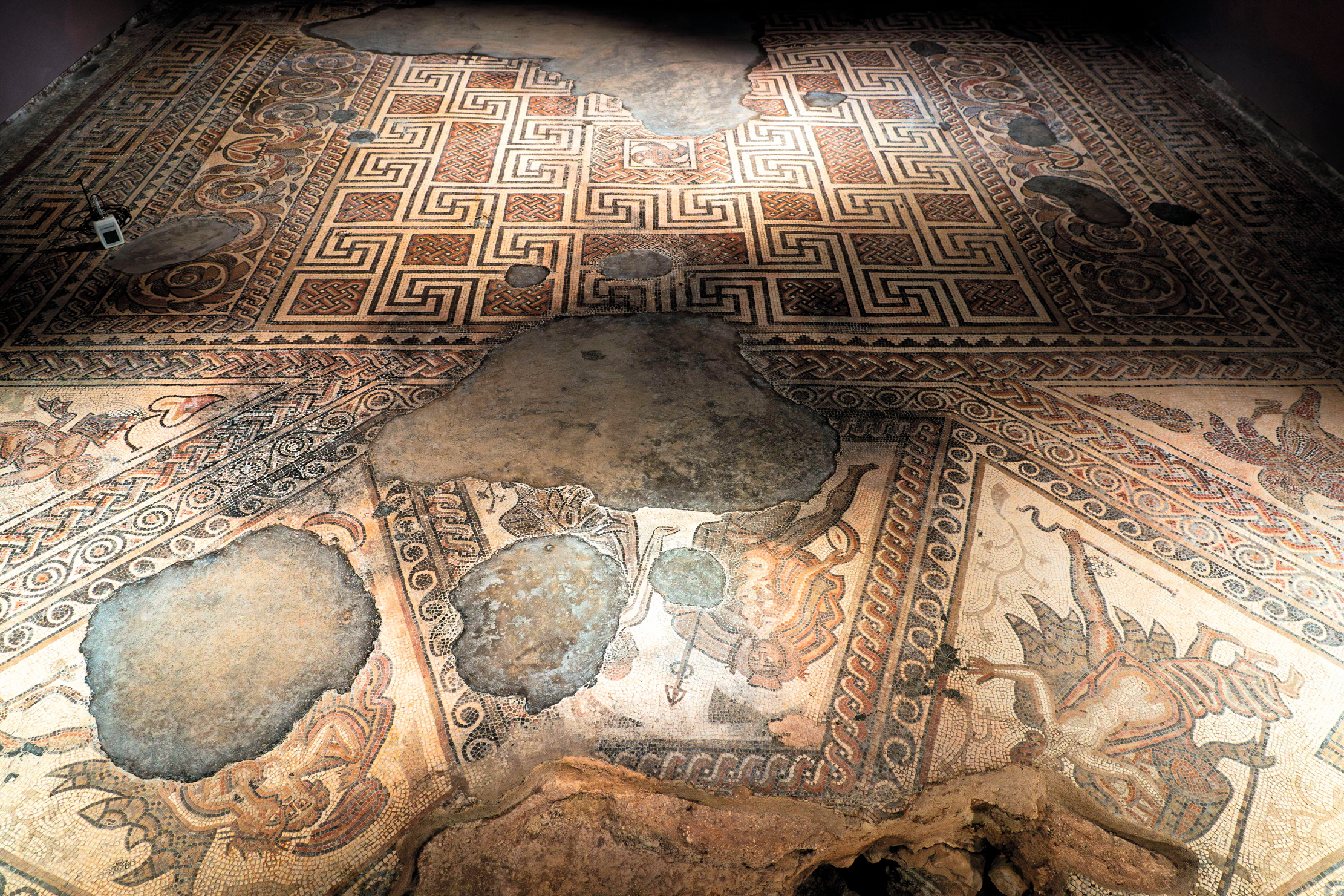 The Triclinium (dining room) within the west range of Chedworth Roman Villa. The mosaic floor shows myths associated with Bacchus, god of wine. UK
