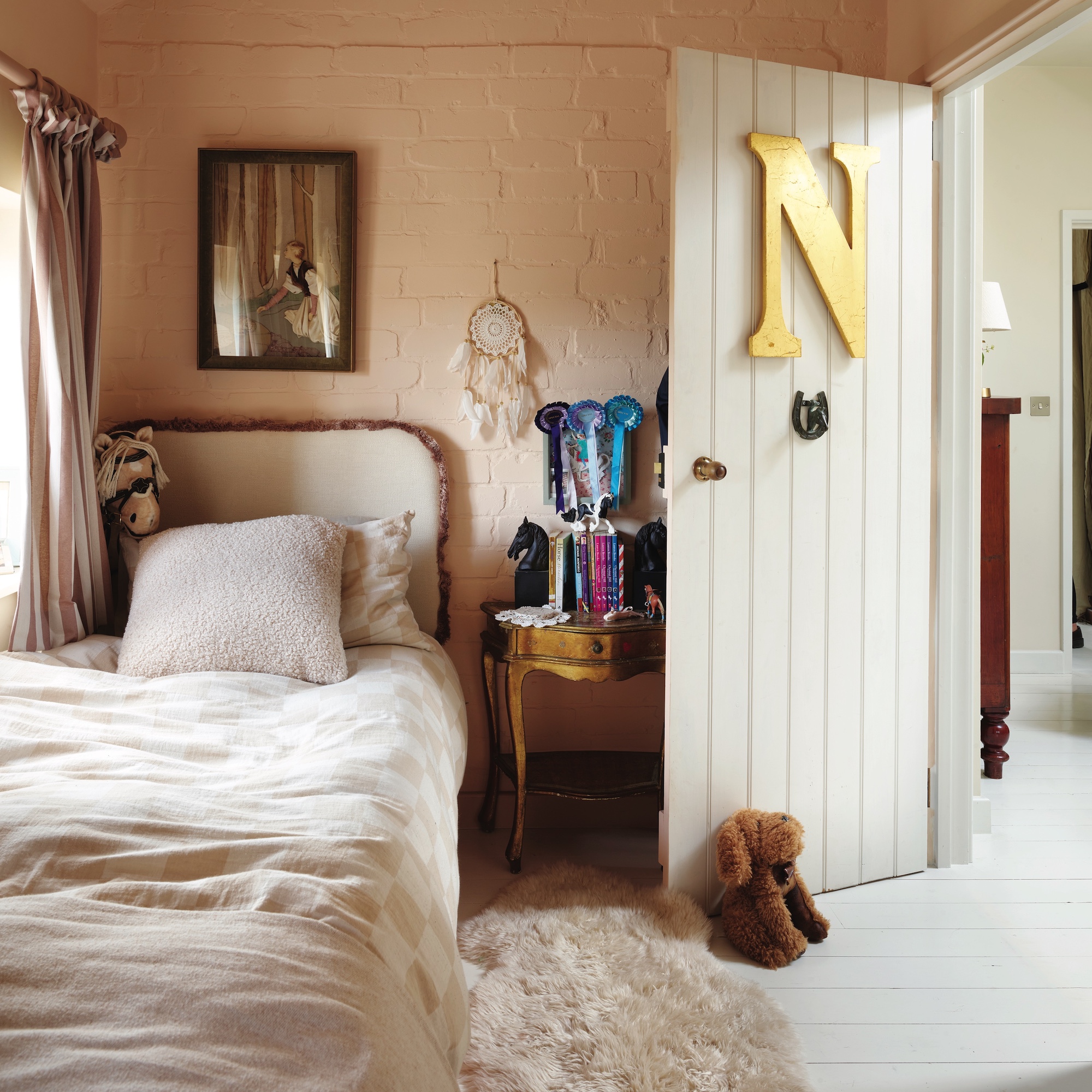 girls' bedroom with single bed and brick walks painted pale pink