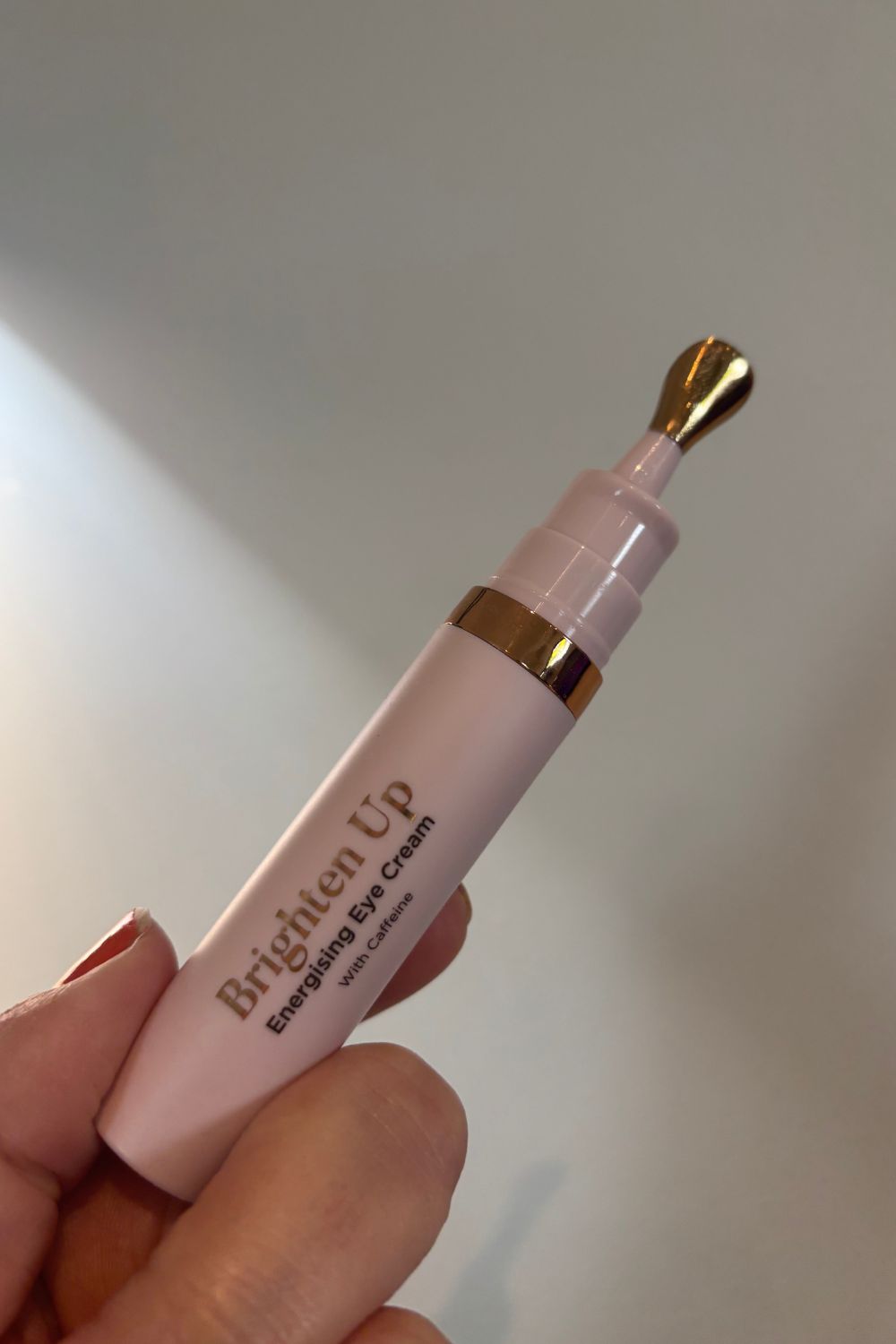 A hand holding sculpted by aimee eye cream