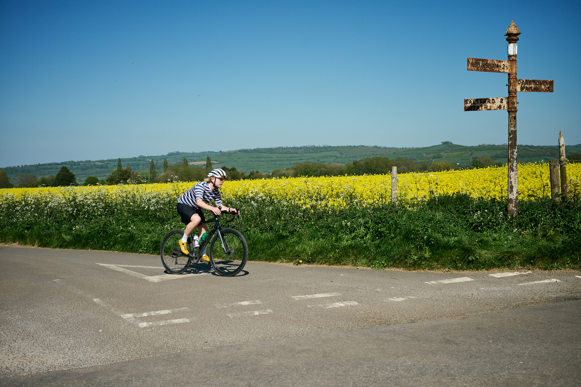 A cyclist rides past a field