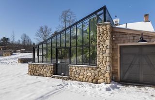 modern greenhouse with stone base in winter