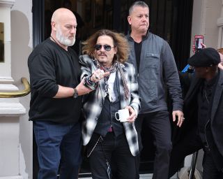 Johnny Depp being escorted out of U.K. hotel