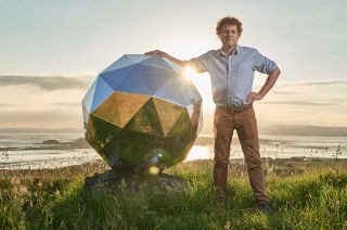 Rocket Lab founder and CEO Peter Beck stands with the "Humanity Star" satellite, which launched aboard the second-ever flight of the company's Electron rocket, in January 2018.