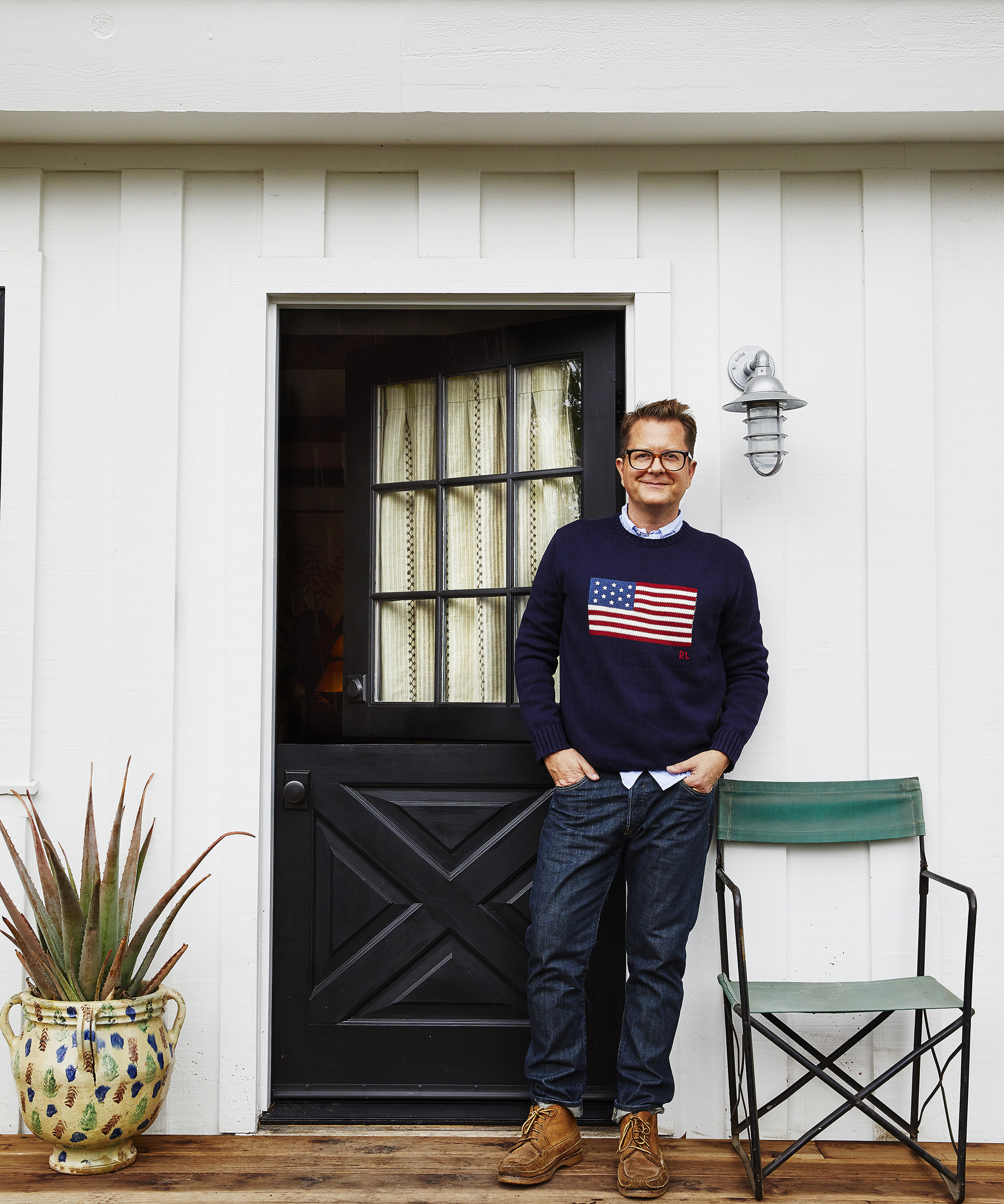 Nathan Turner standing and smiling outside a white clapboard house