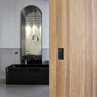 Room with grey tiled flooring and wooden door