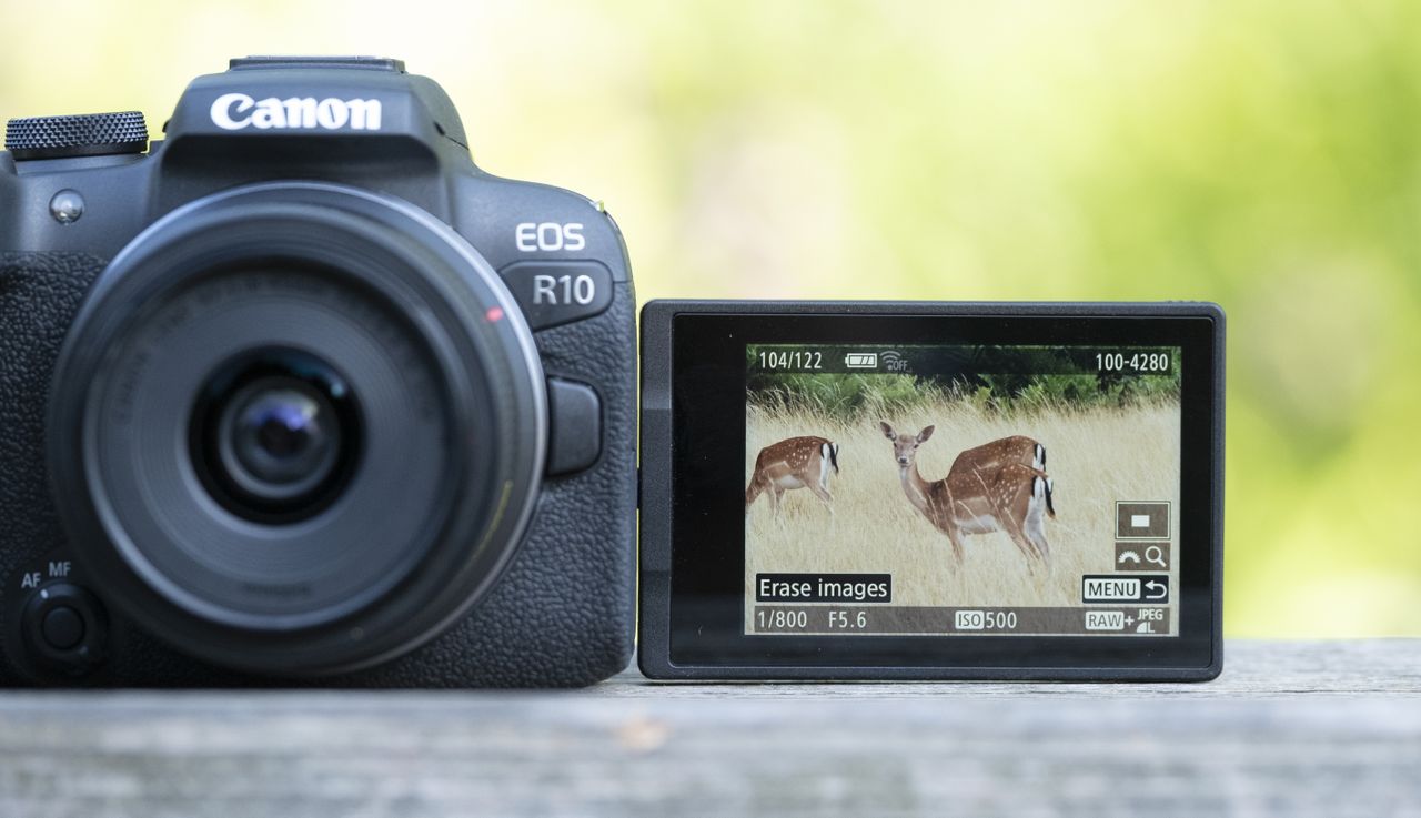 The Canon EOS R10 camers sitting on a wooden bannister