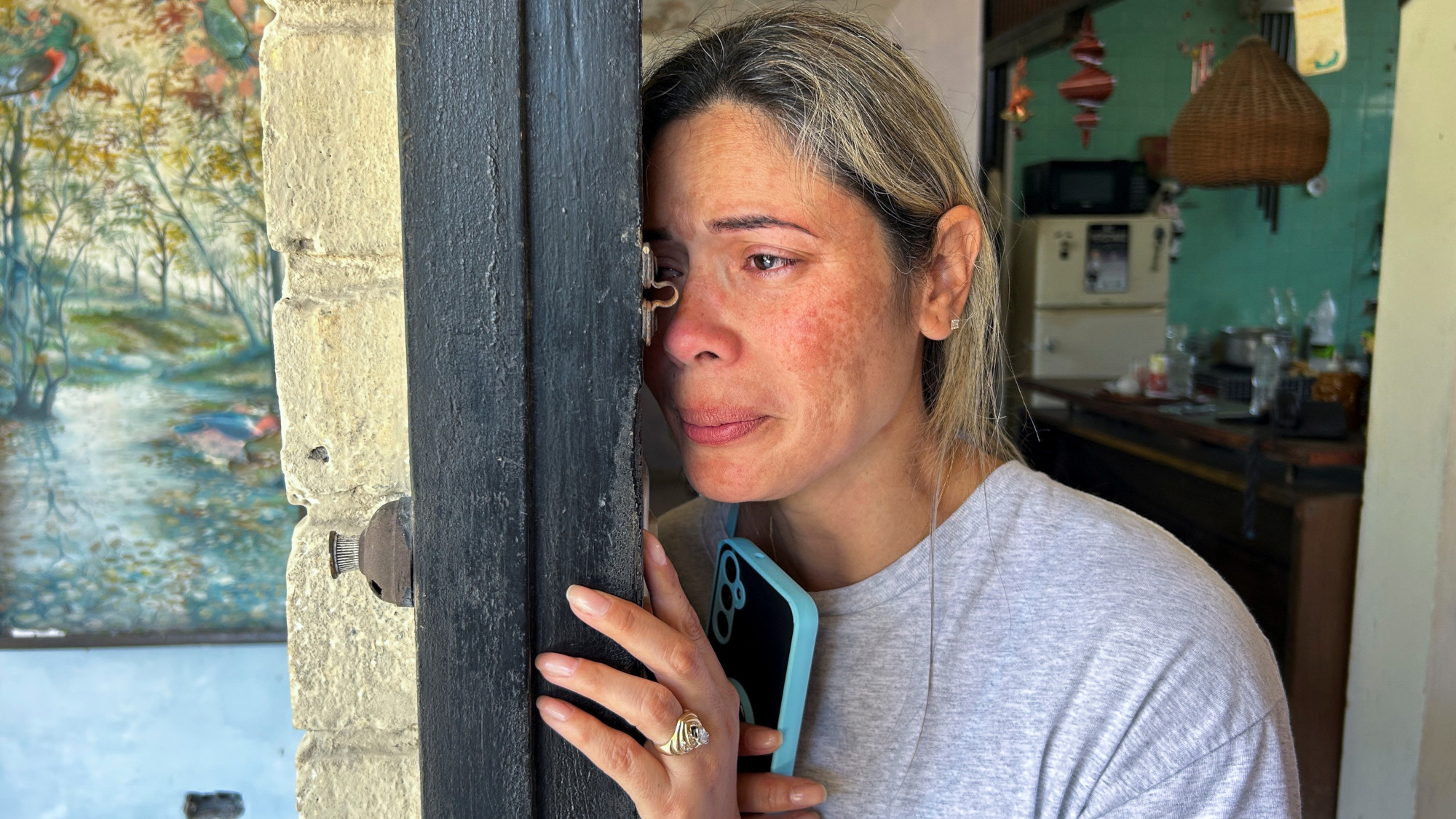 Heidy Sanchez cries after speaking to her daughter, who is in the U.S., during an interview at her home in Cuba