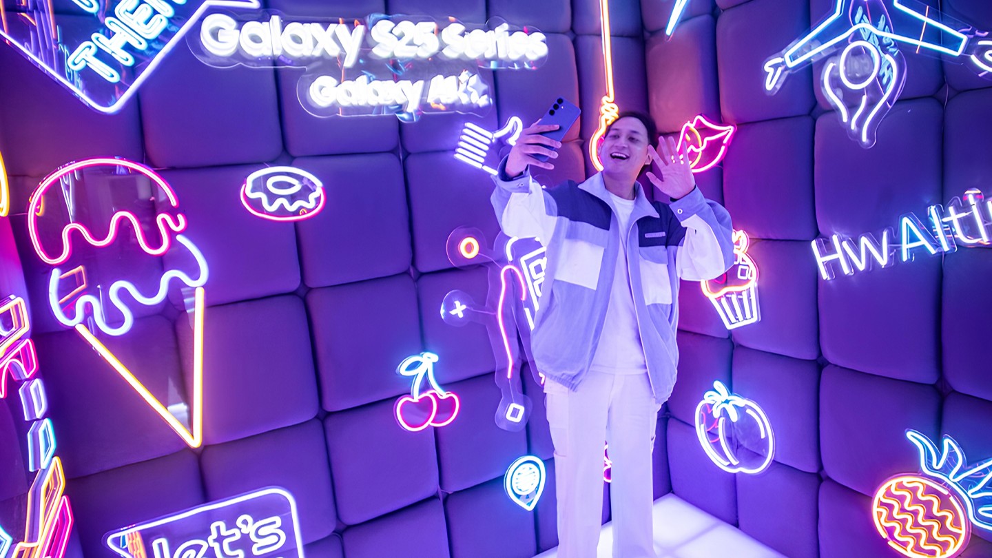 Woman posing in front of neon Samsung Galaxy S25 wall