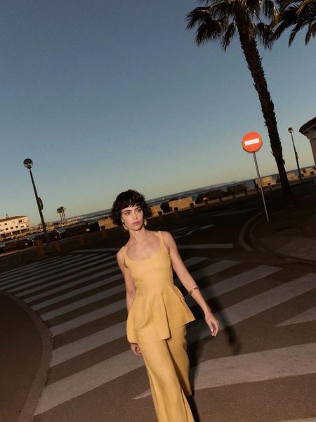 Woman walking across street in yellow jumpsuit