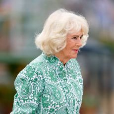Queen Camilla turned to the side wearing a green dress
