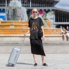 Blonde model holding a silver suitcase